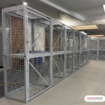 A bank of mesh equipment lockers installed in a technical office. Each locker is equipped with a strong shelf made with expanded metal.