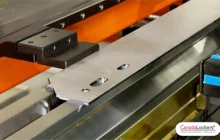 A view of the press brake die with a part prior to forming a part for a bike locker frame.